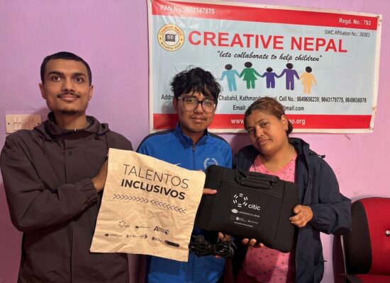 Foto con niños Nepalis recogiendo el ordenador del grupo TALIONIS